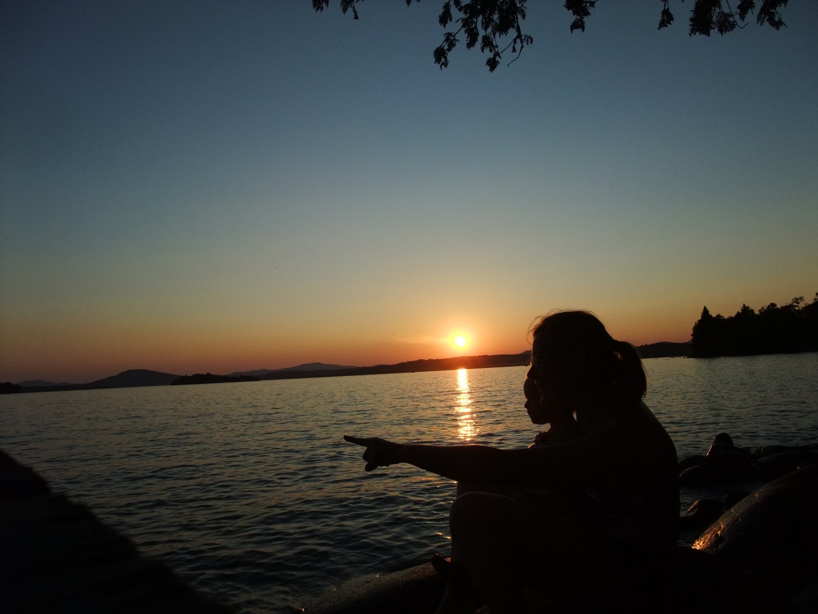silhouette of mother and child at sunset with a lake background